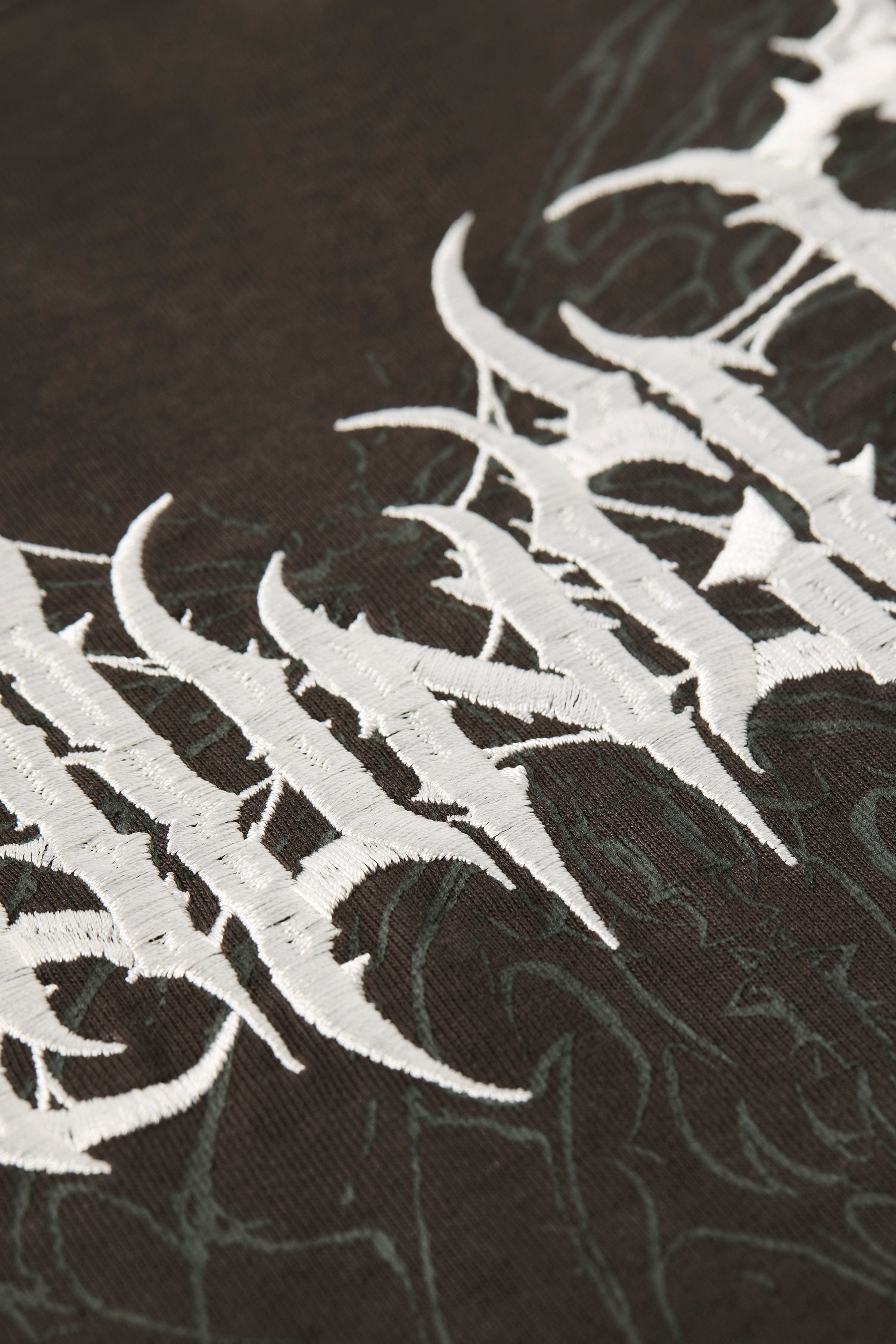 4149 - Gothic Tees- Oversized tee with bold gothic-inspired graphics on the back, structured yet comfortable, offering a sharp, wearable edge and statement-making style.