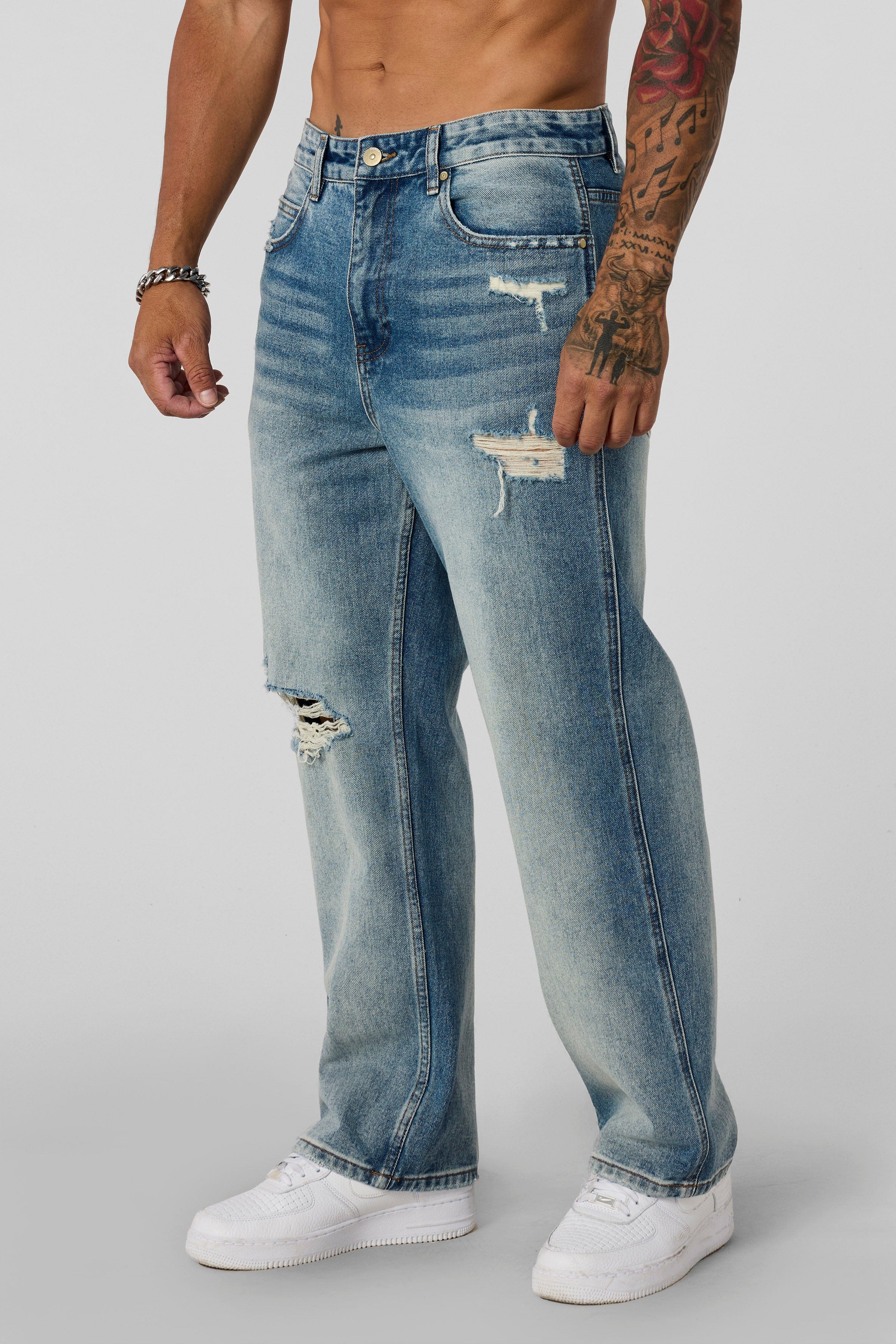 6025 - Straight Fit Ripped Jeans- Straight-leg jeans made from heavy 415 GSM cotton, structured yet softening over time, featuring minimal detailing for a vintage-inspired, timeless look in Blue Wash.