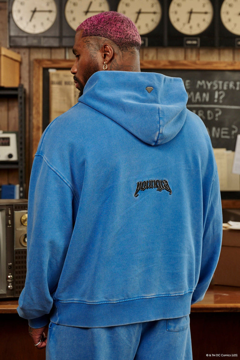 5079 - Superman Legacy Hoodies- Superman Legacy Hoodie in 460 GSM soft cotton with relaxed fit, featuring a chenille Superman logo patch on the chest and a clean acid-washed finish in Blue Wash