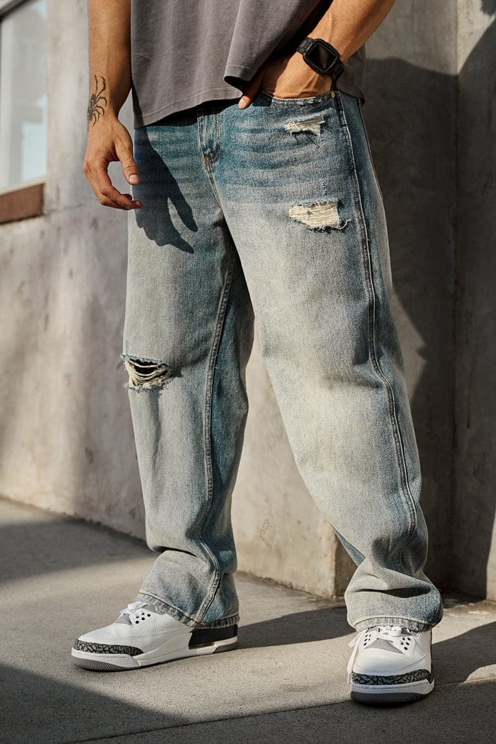 6025 - Straight Fit Ripped Jeans- Straight-leg jeans made from heavy 415 GSM cotton, structured yet softening over time, featuring minimal detailing for a vintage-inspired, timeless look in Blue Wash.